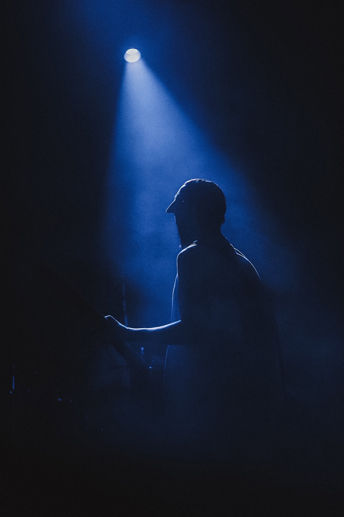 Musician silhouetted in blue stage light