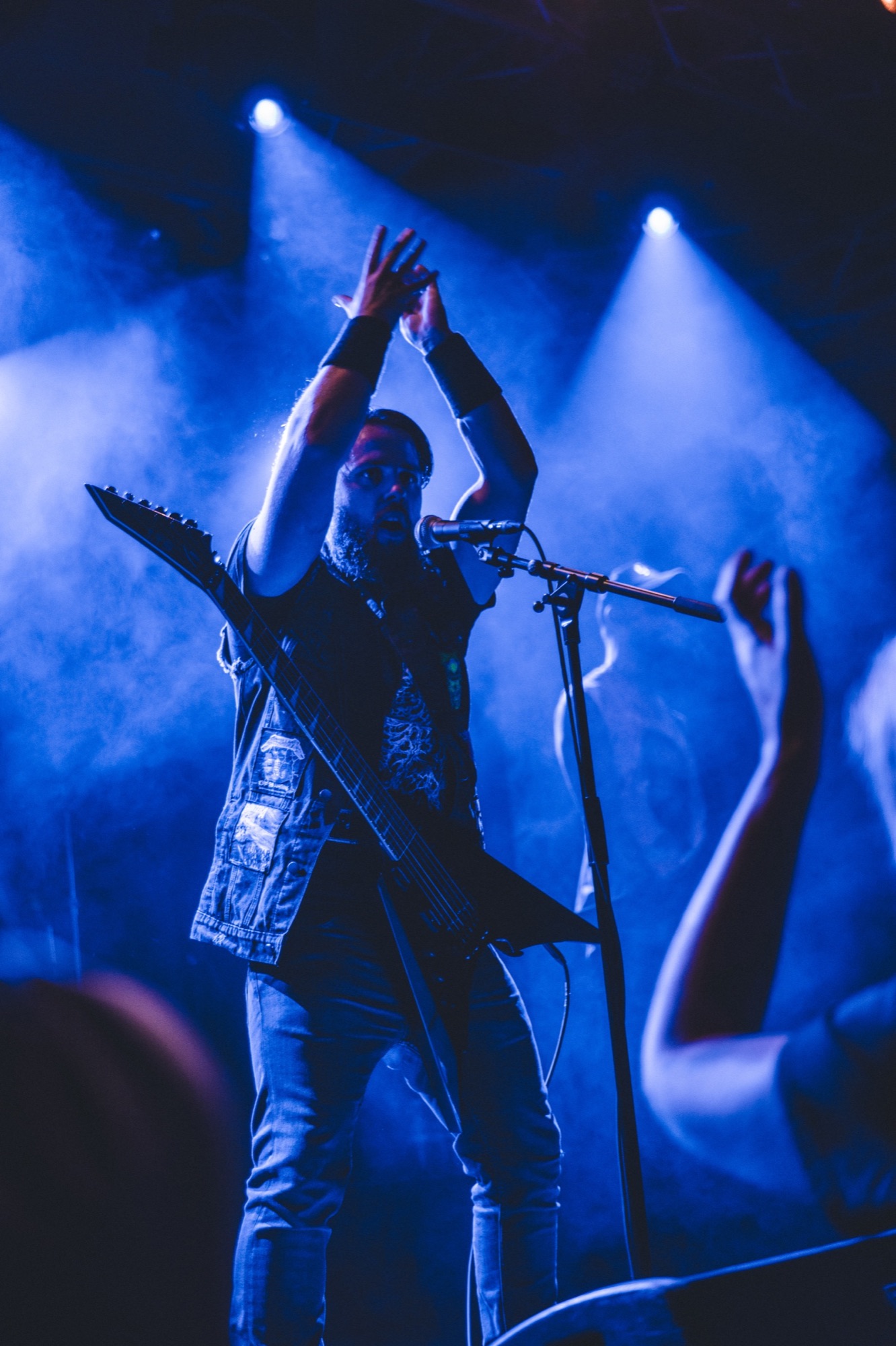 Frontman beneath blue spotlights